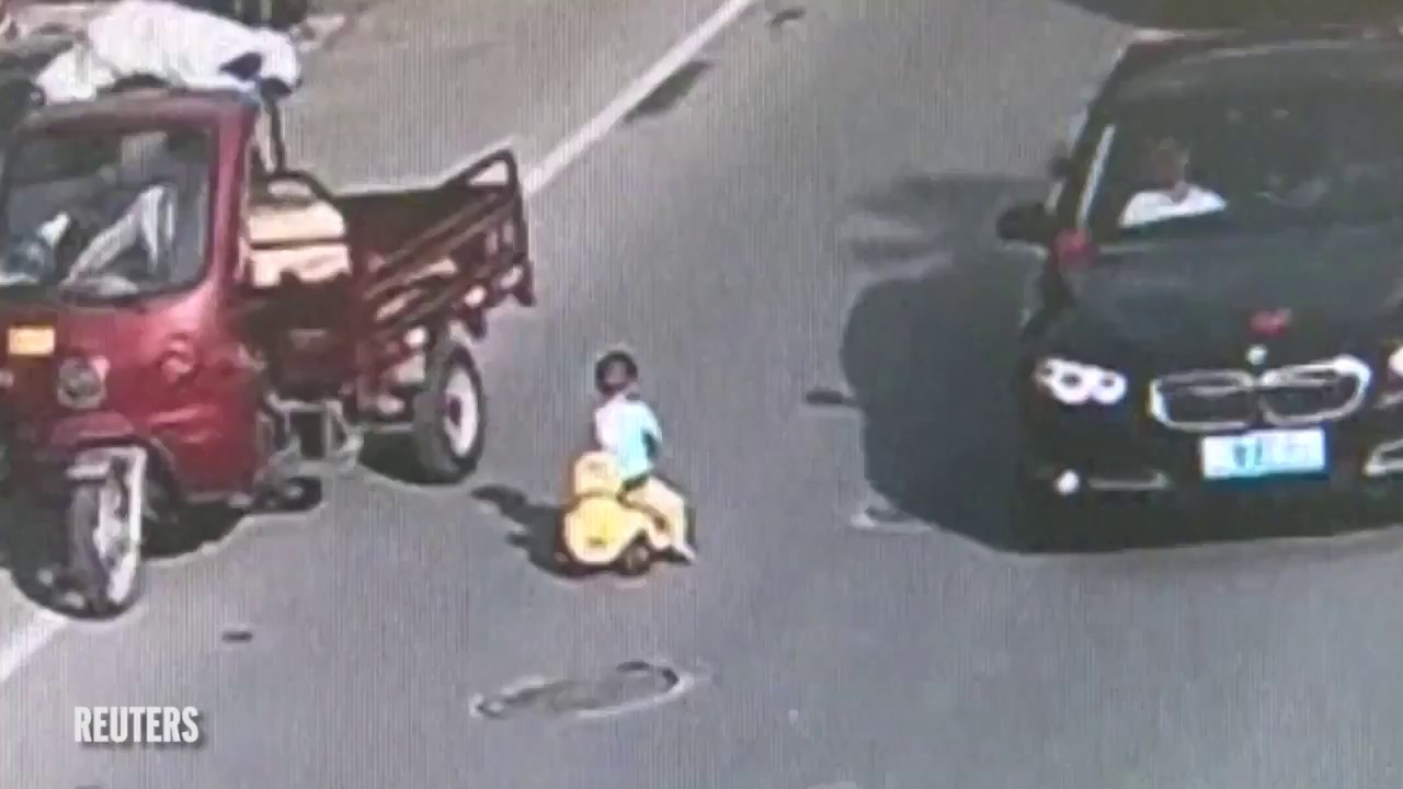 Criança brinca no meio de estrada em hora de ponta na China