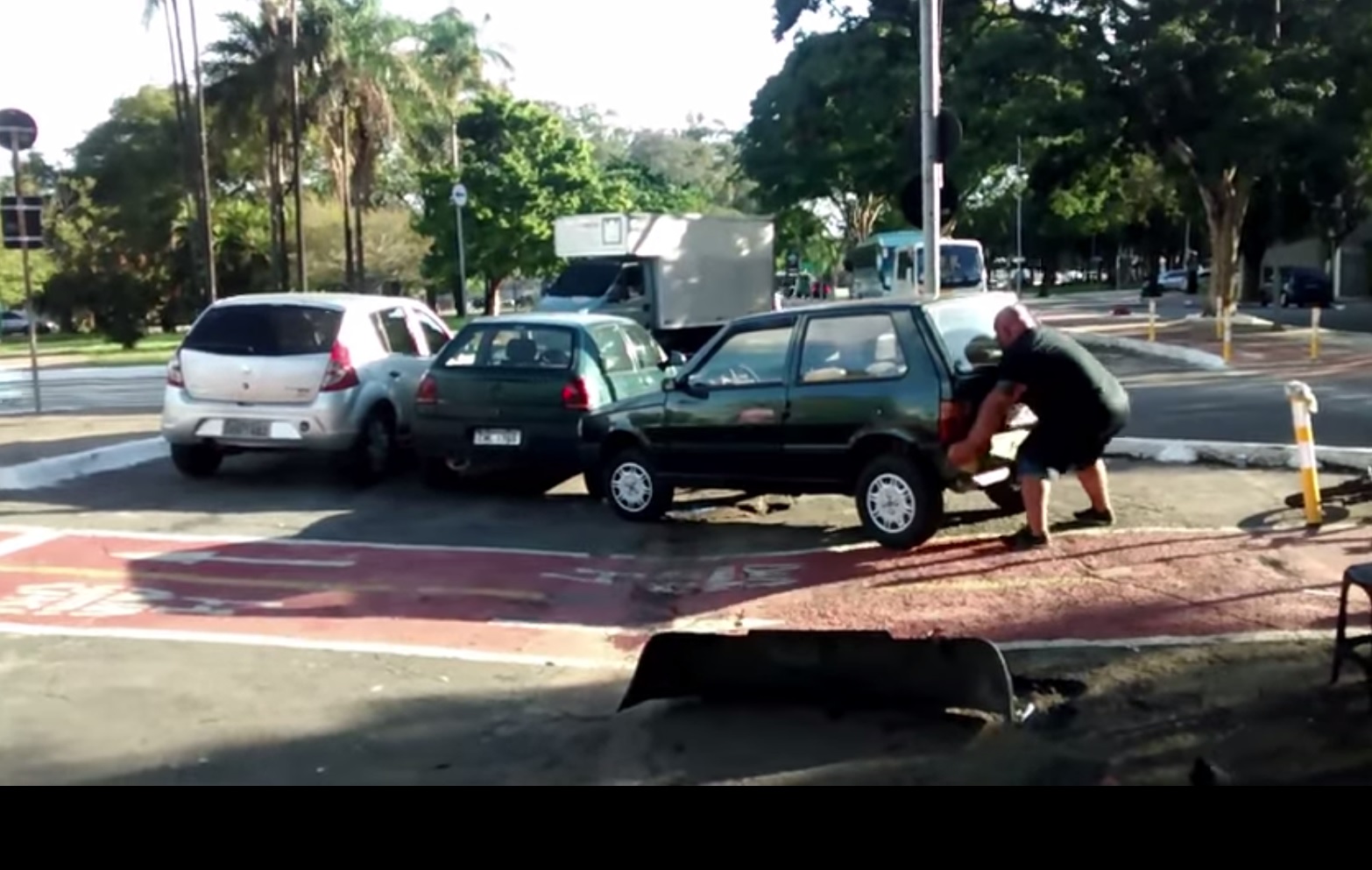 Homem arrasta carro mal parado para poder passar de bicicleta [vídeo]