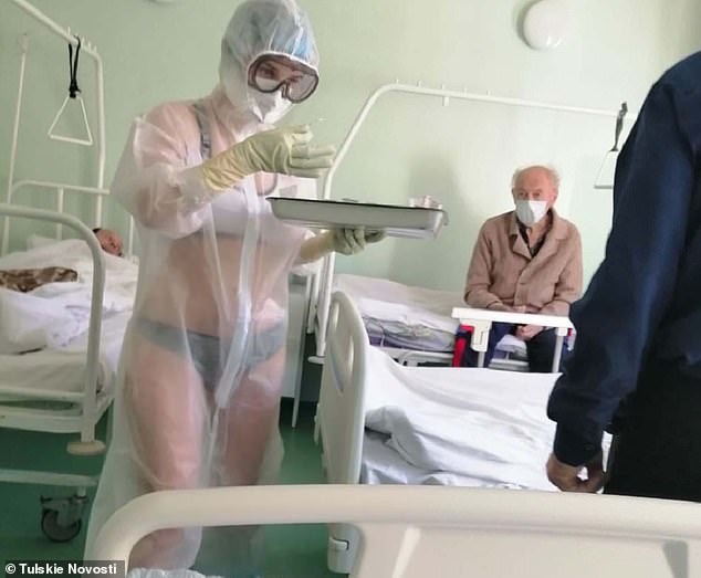 Fotografia mostra enfermeira a usar apenas roupa interior por baixo de fato de proteção transparente